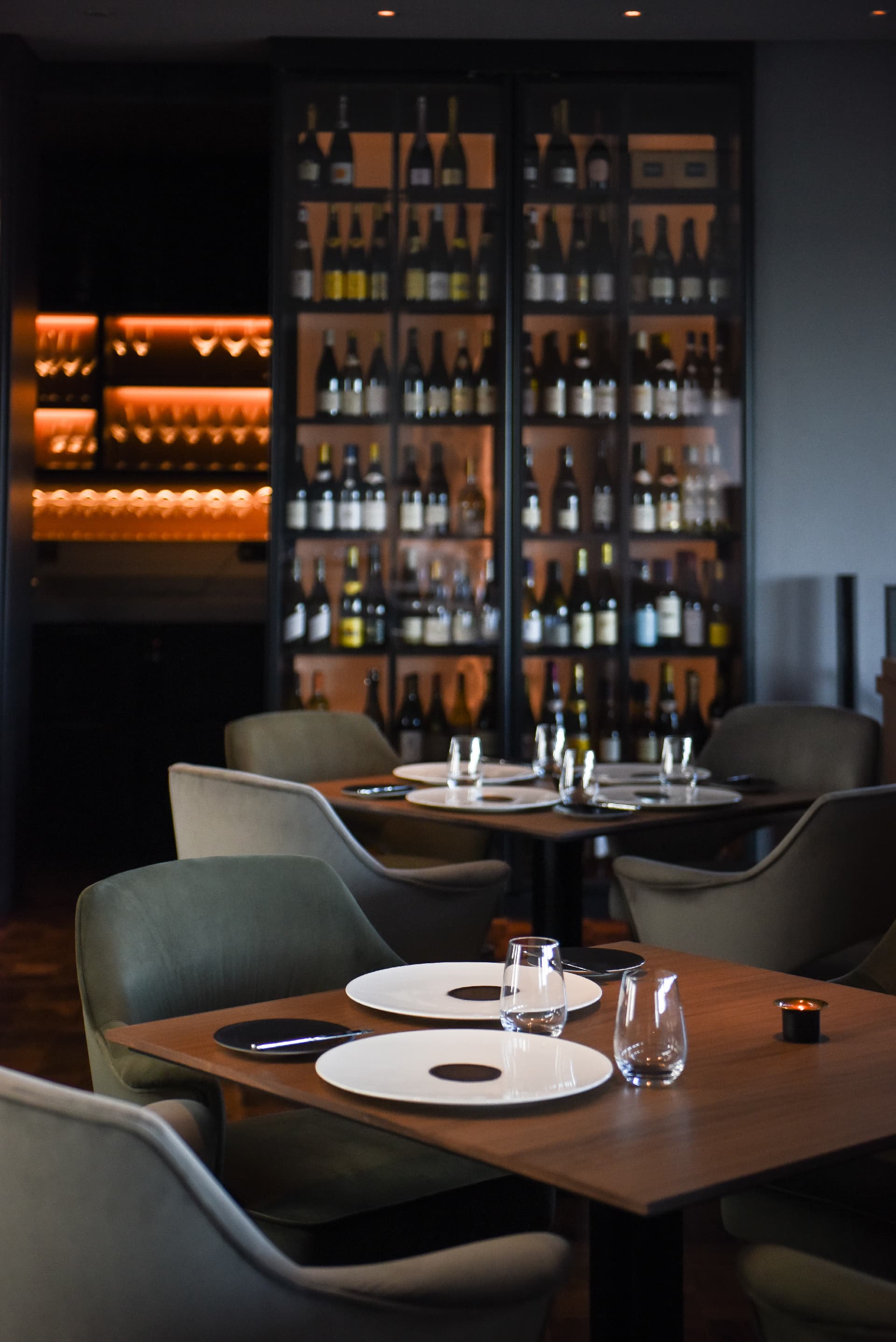 Indoor dining room with a wine bottle wall and set tables